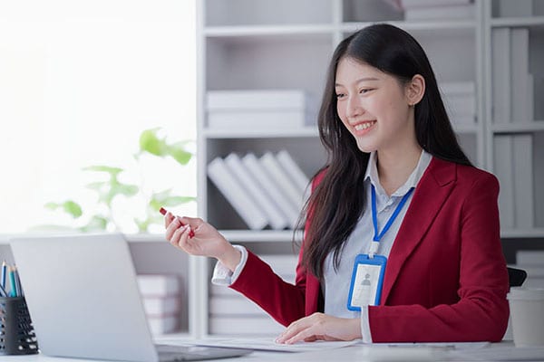 A business woman sat working at a laptop smiling