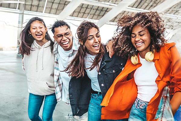 A group of young adults huddled together smiling